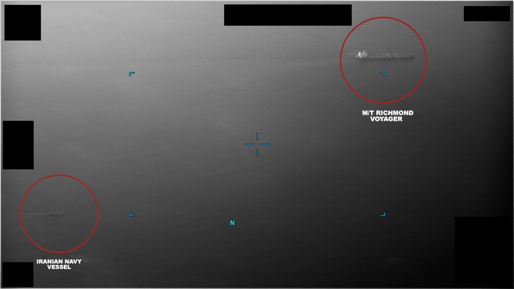 Iranian naval vessel maneuvering near a commercial oil tanker in the Gulf of Oman
