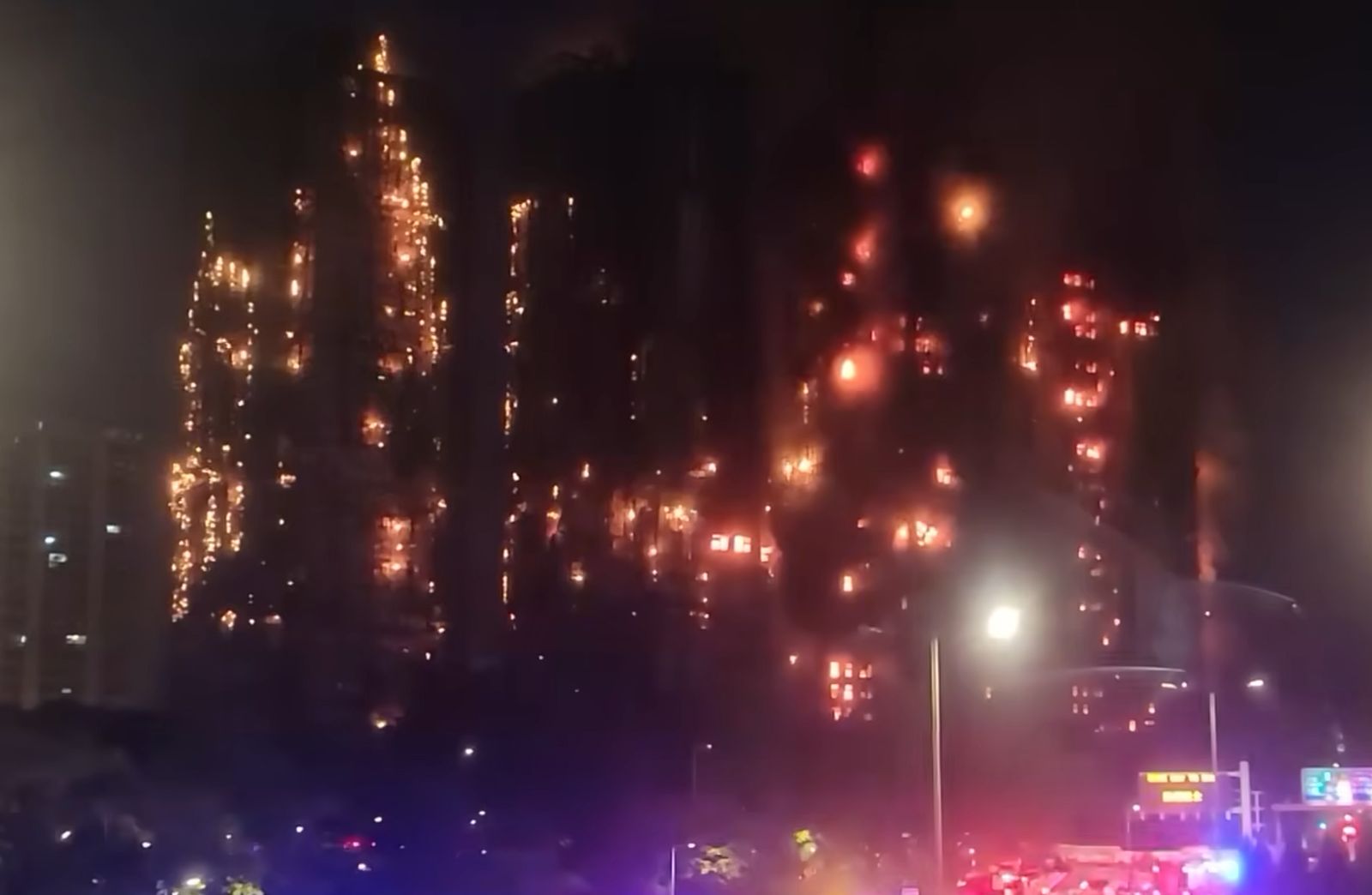 Night view of the Wang Fuk Court towers ablaze during the Hong Kong Tai Po fire on November 26, 2025, with flames spreading across the scaffolded buildings