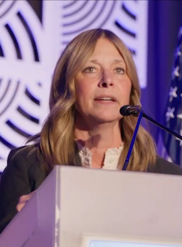 Who is Amy Acton — Acton speaking at a conference podium in 2025