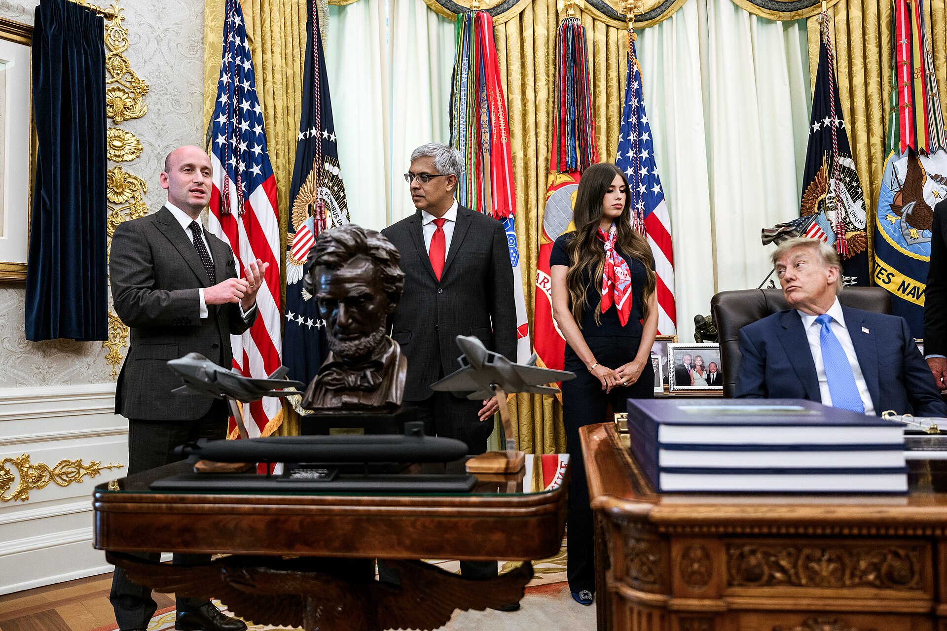President Donald Trump seated at the Resolute desk in the Oval Office during an executive-order event on August 10, 2026