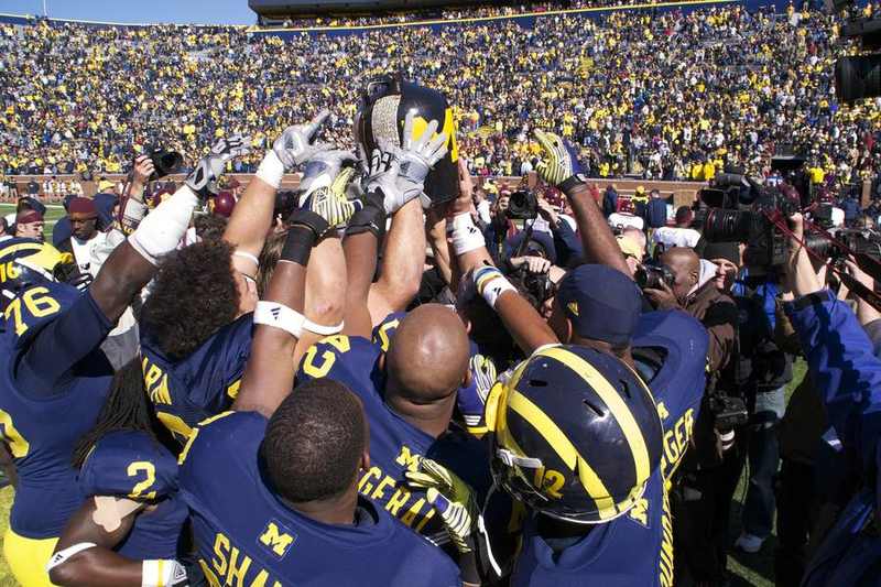 Minnesota and Michigan players collide during an earlier Little Brown Jug rivalry game