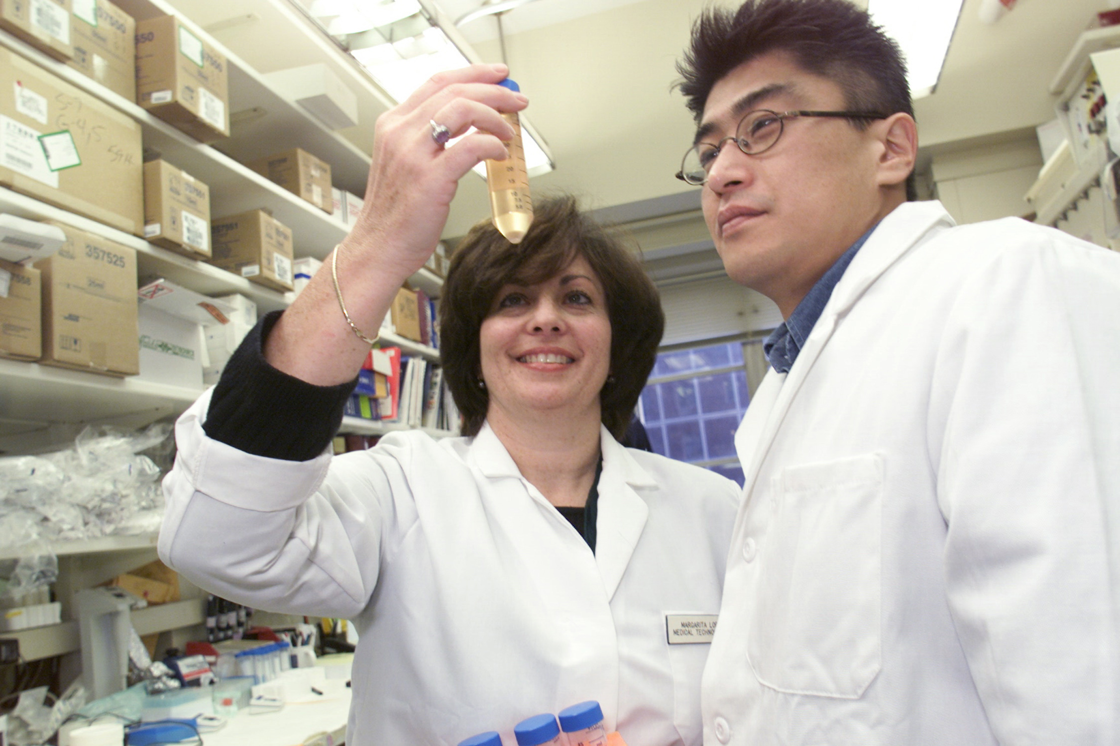 Laboratory scientists examining a vial in a research laboratory — the Kennedy peptides policy requires lab certificates, traceable ingredients and quality testing for compounded peptides
