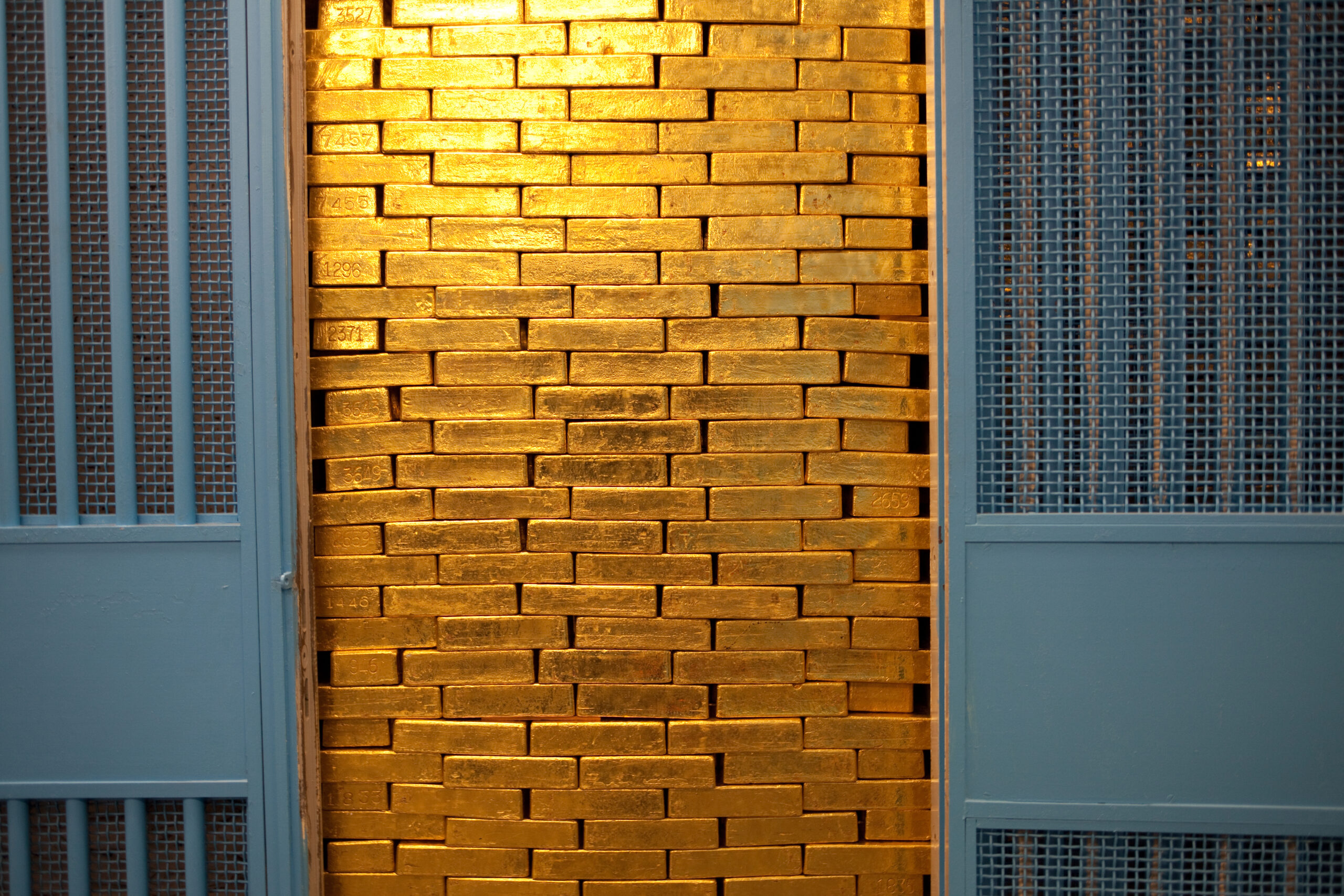 A vault wall stacked with gold bars — spot gold held near $4,176 an ounce on Monday, far below January's $5,597.23 record but at levels that would have been records in any prior year