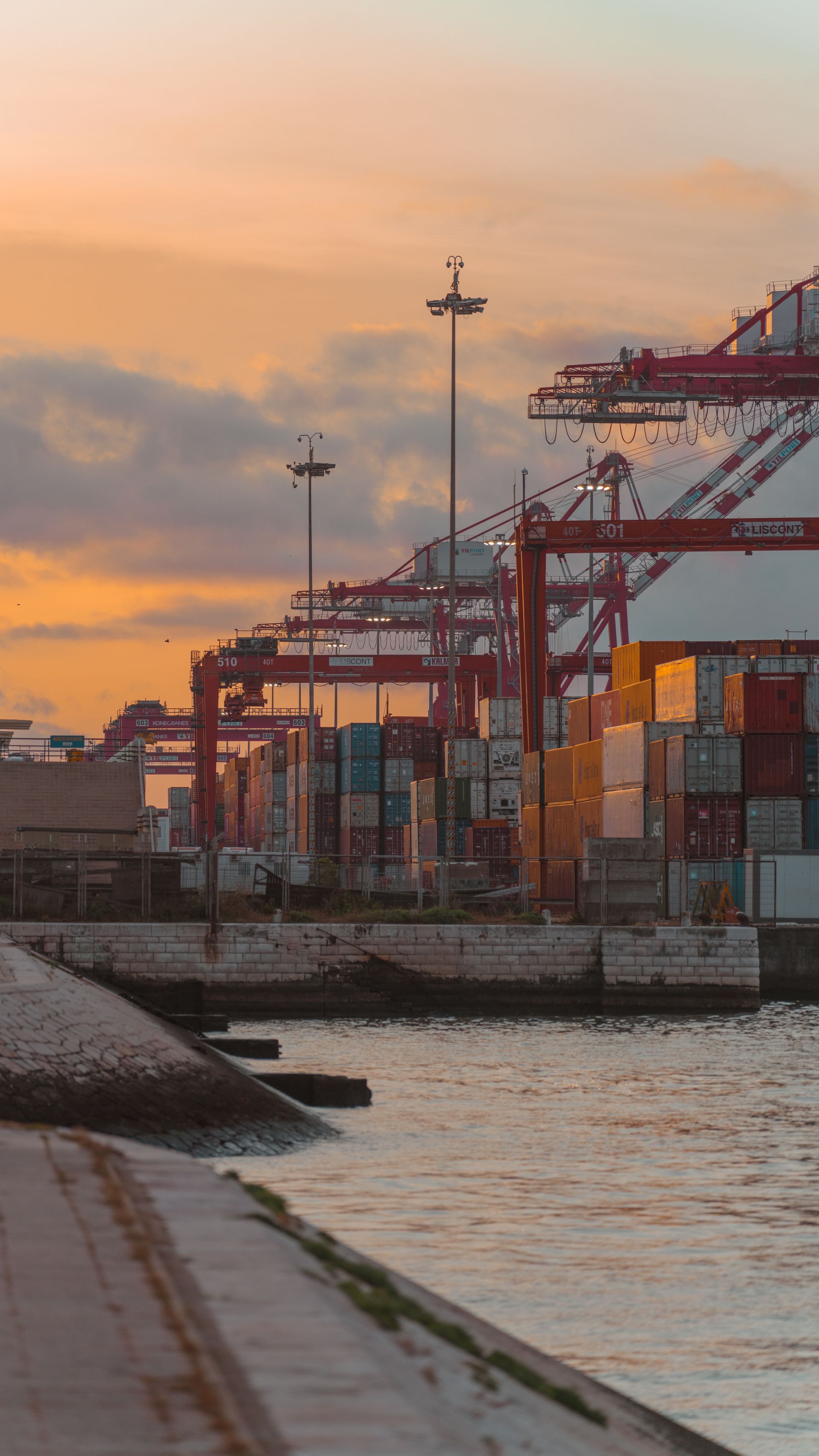Container cranes and stacked containers at a shipping port at sunset — Ukraine's grain exports depend on keeping ports like Odesa open