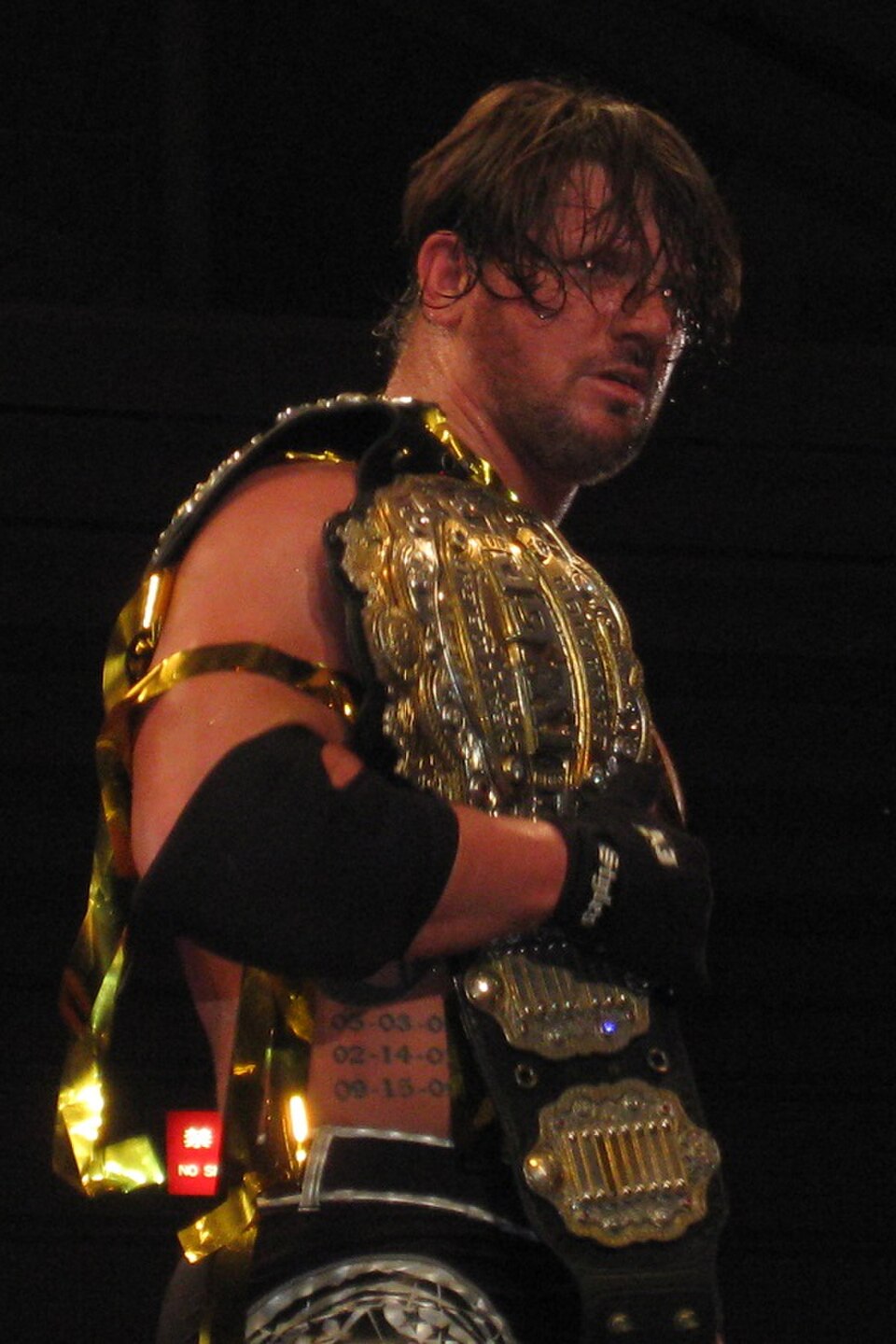 AJ Styles holding the IWGP Heavyweight Championship during his New Japan and Bullet Club career