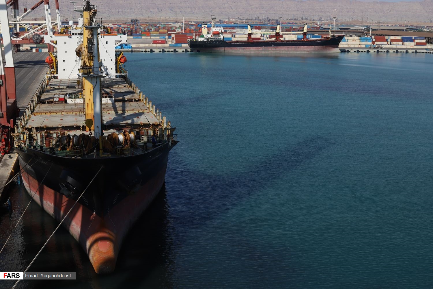 Iran sanctions evasion network — cargo ships and stacked shipping containers at the Shahid Rajaee container terminal at Bandar Abbas, Iran