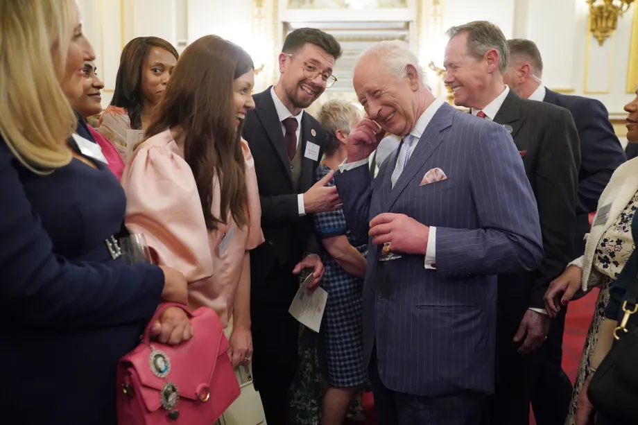 King Charles III meeting guests at a reception for community-based cancer initiatives