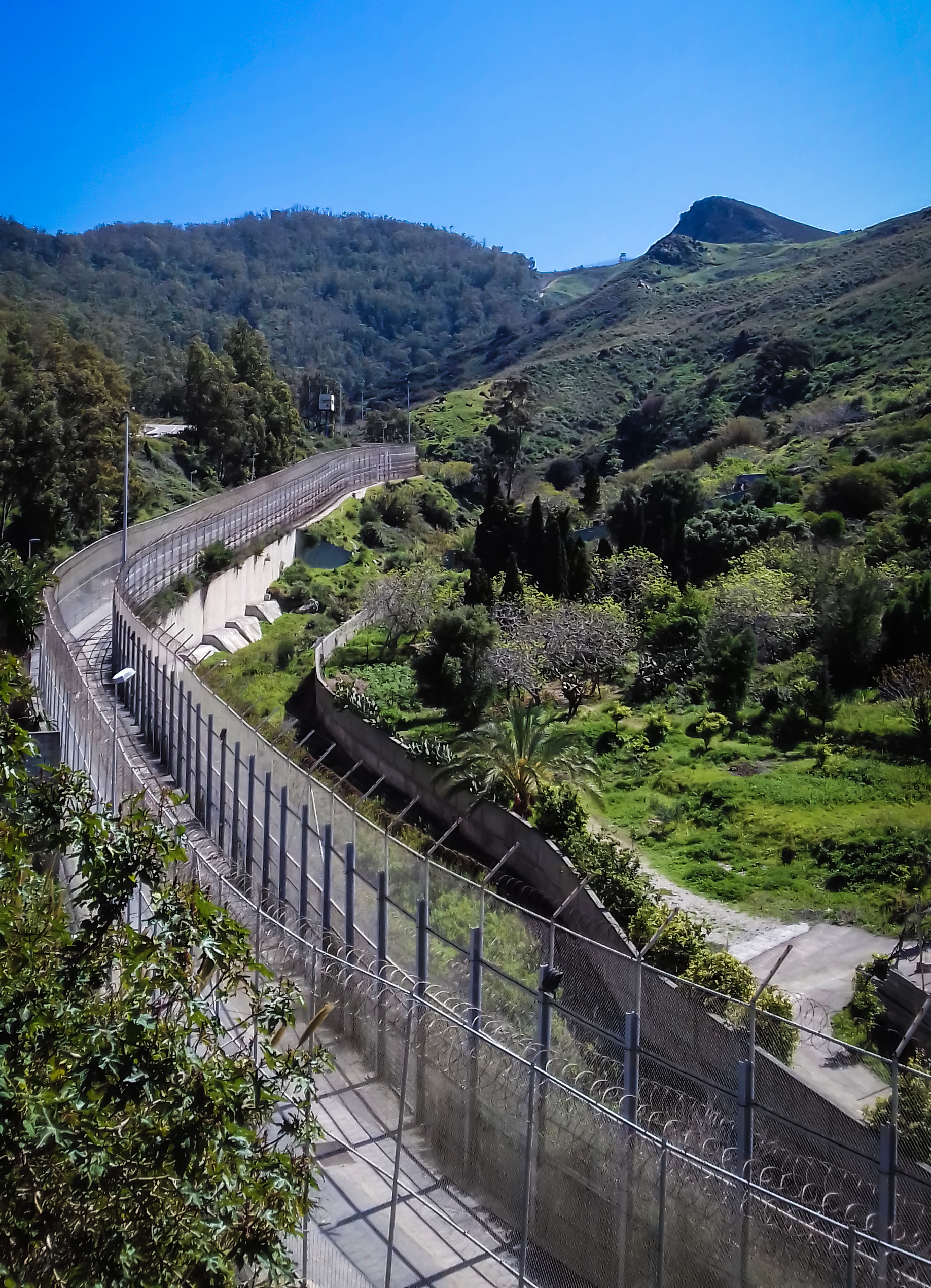 The parallel fences of the Ceuta border barrier seen from the Spanish side