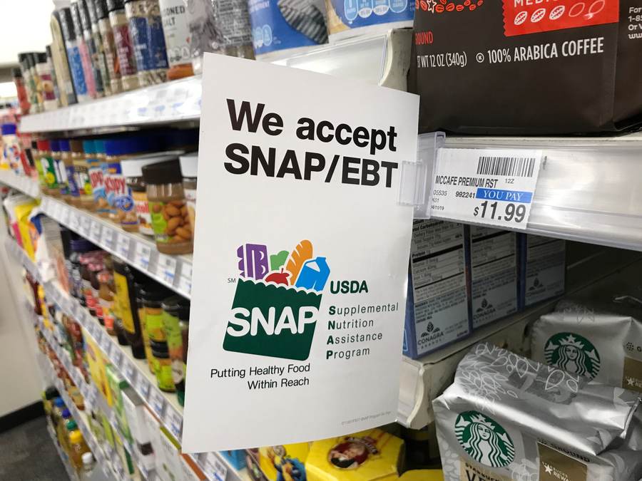 SNAP and EBT acceptance sign displayed beside grocery-store shelves as October 2026 benefit levels take effect