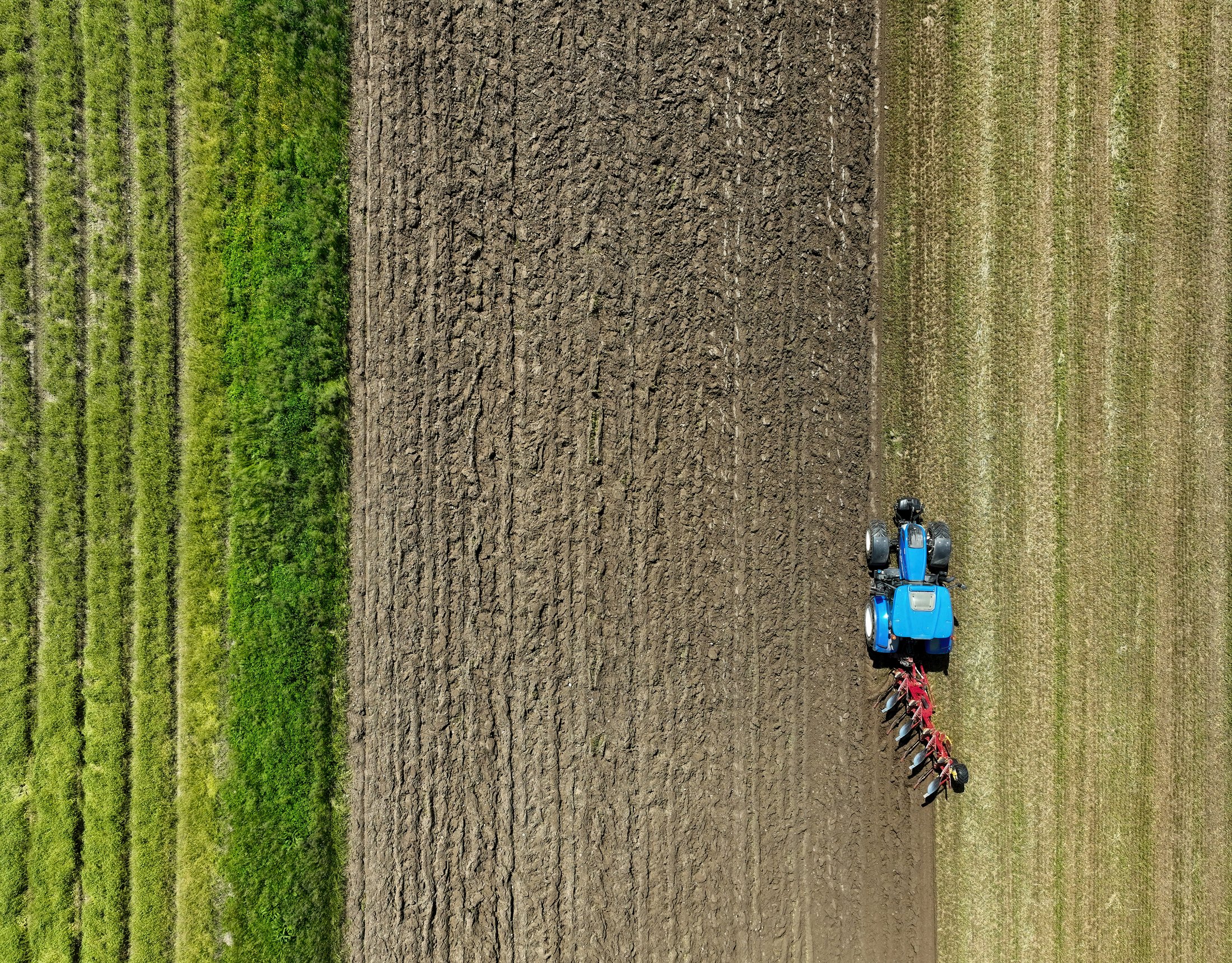 New Holland tractor plowing a field, illustrating dyed diesel use by farmers
