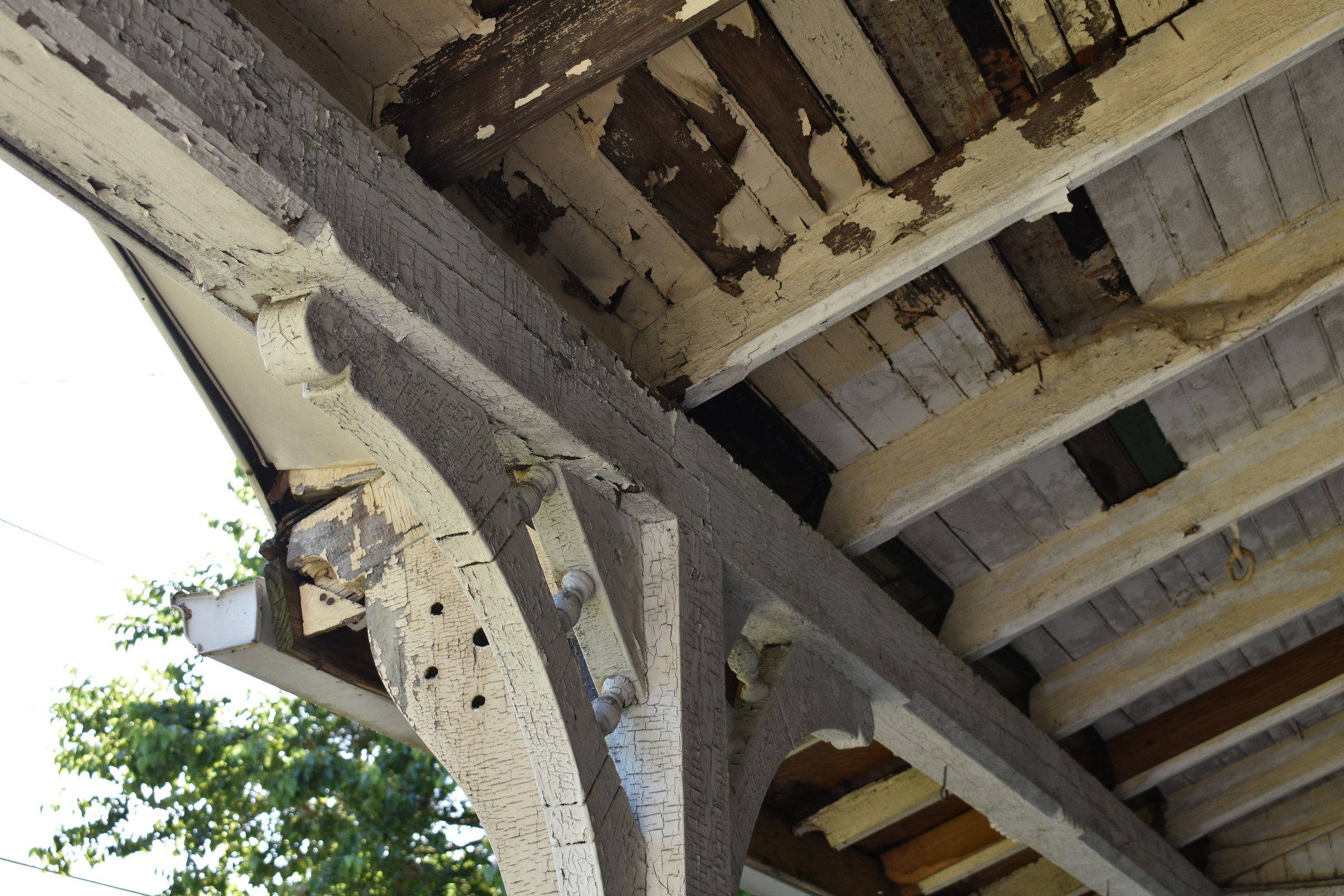 Lead paint cracking and flaking off the woodwork of a porch — deteriorating paint is a leading source of lead exposure behind the WHO lead poisoning warning