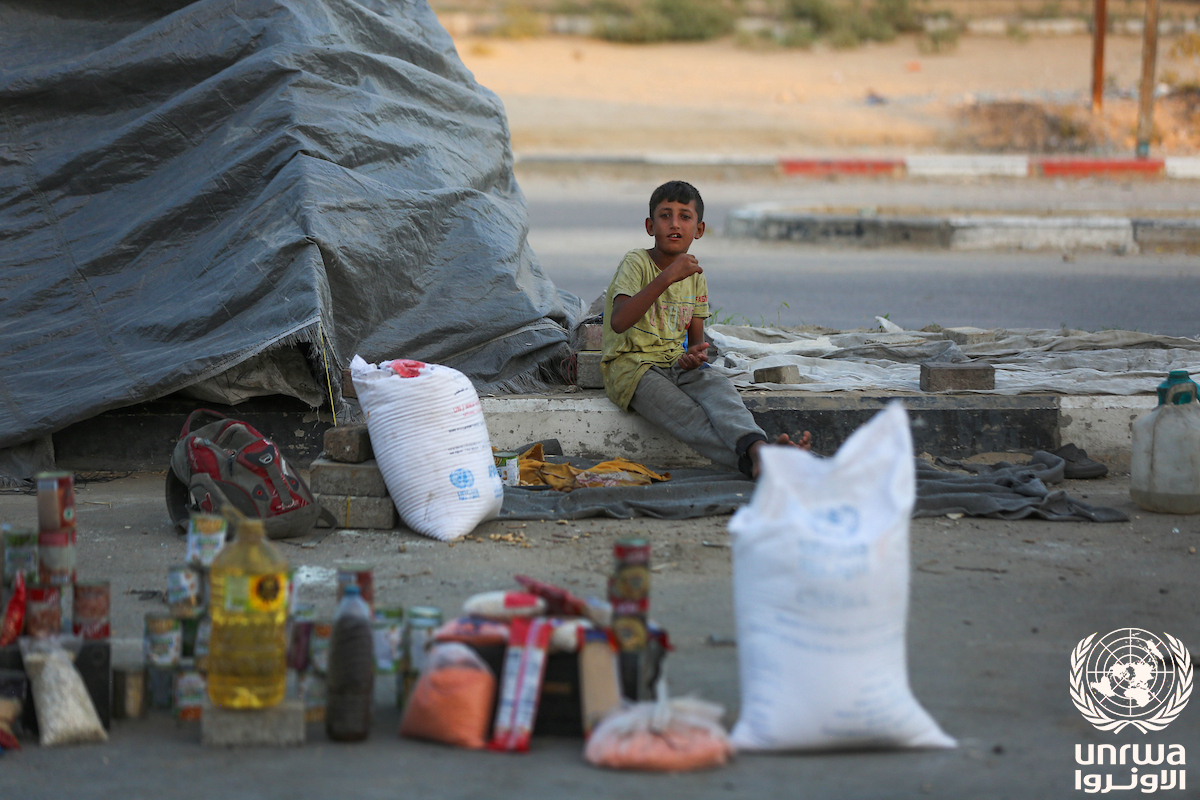 A displaced Palestinian child sits in front of his family's tent east of Deir el-Balah in the Gaza Strip after Israeli army evacuation orders forced families to move again