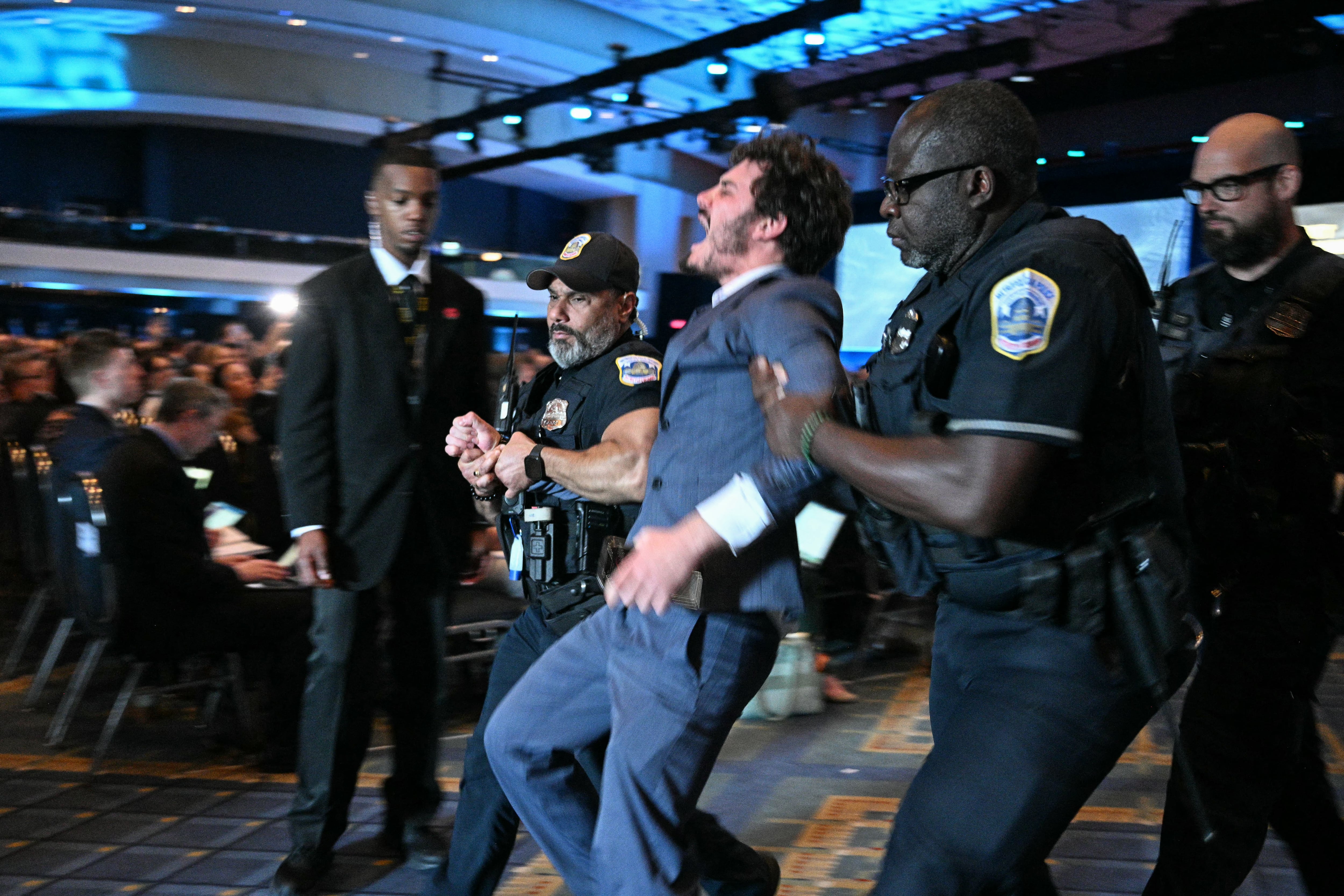 A second protester is removed by security personnel at the AUSA 2026 Annual Meeting and Exposition in Washington — Hegseth protesters AUSA panel