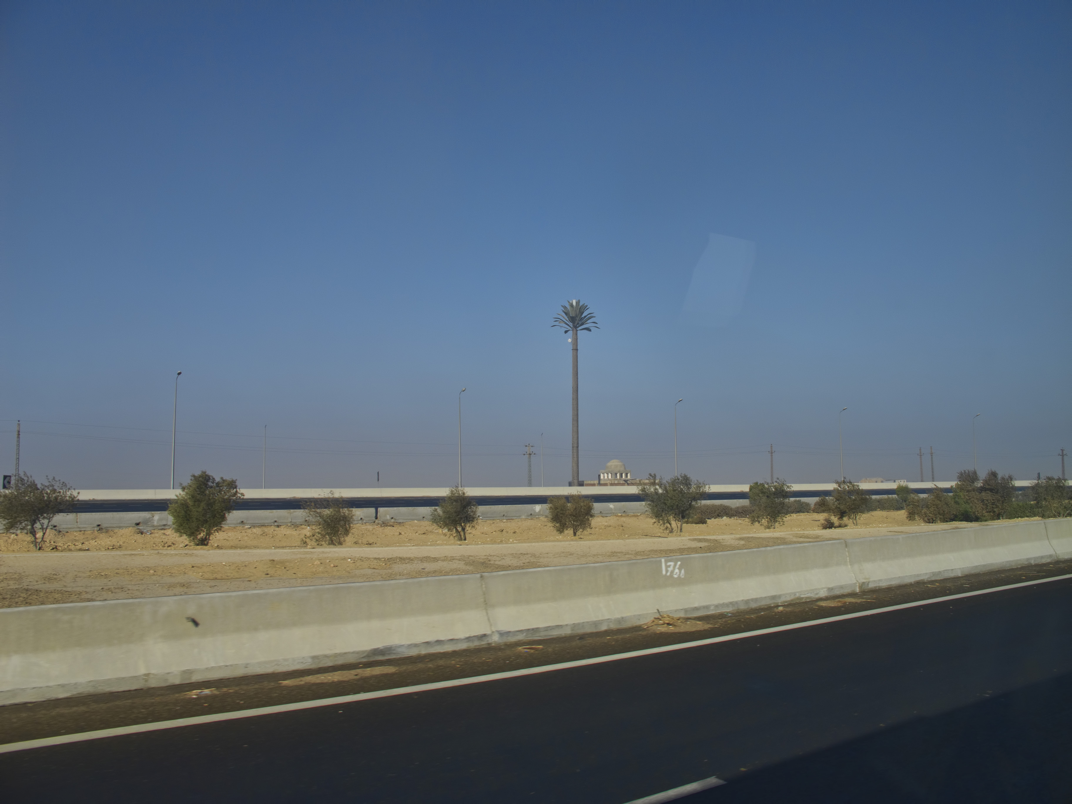 The concrete median of an Egyptian desert highway — high-speed divided roads carry Egypt's long-distance bus traffic