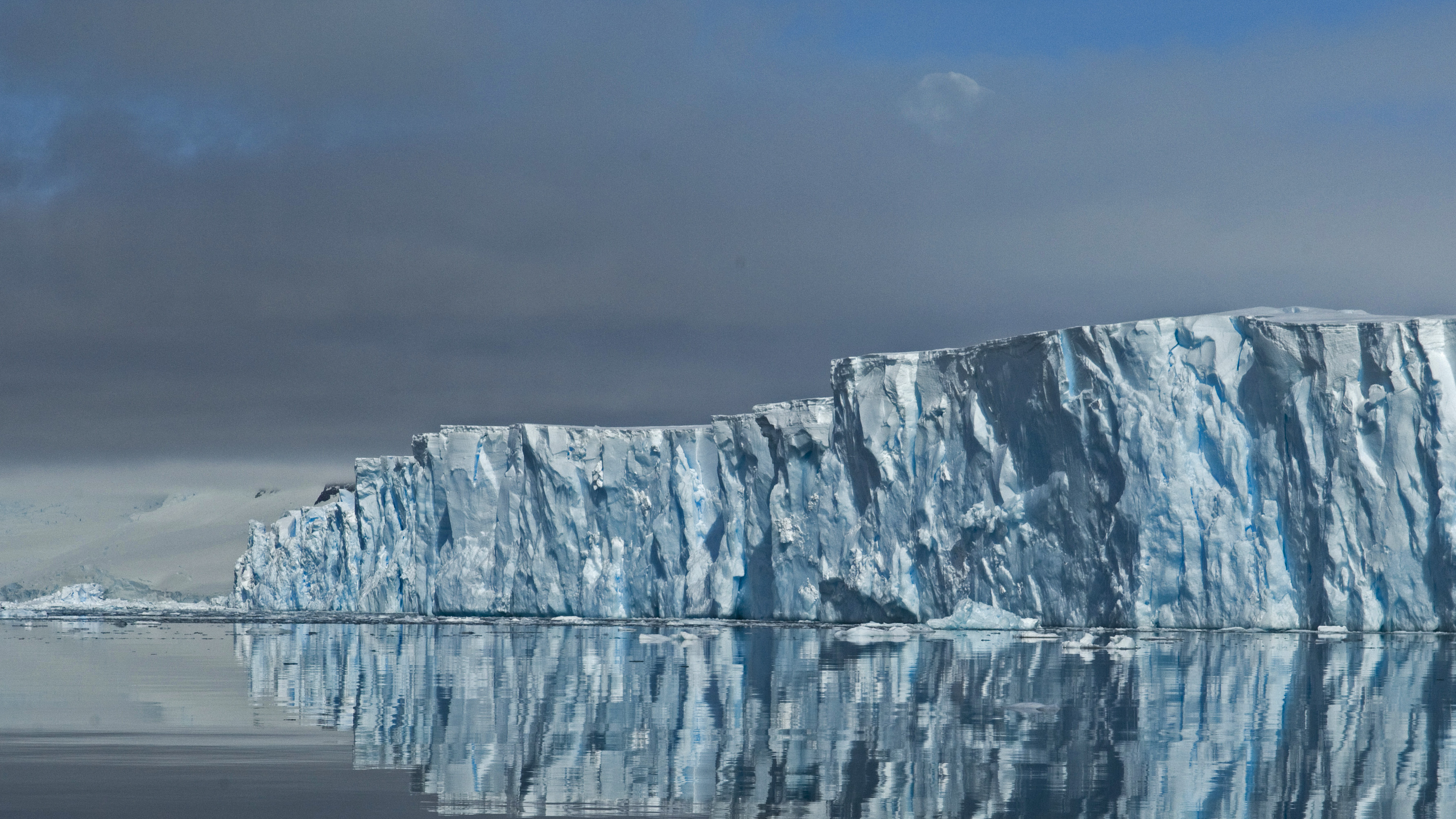 Thwaites Glacier ice front reflected in calm seawater in West Antarctica