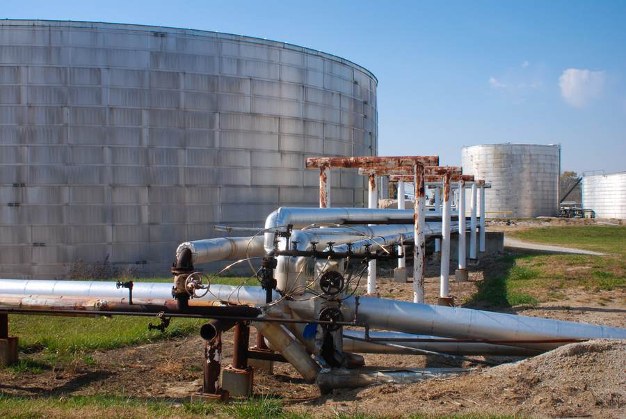 Fuel storage tanks and pipes at a refinery — file photo illustrating the type of infrastructure hit in Port Sudan