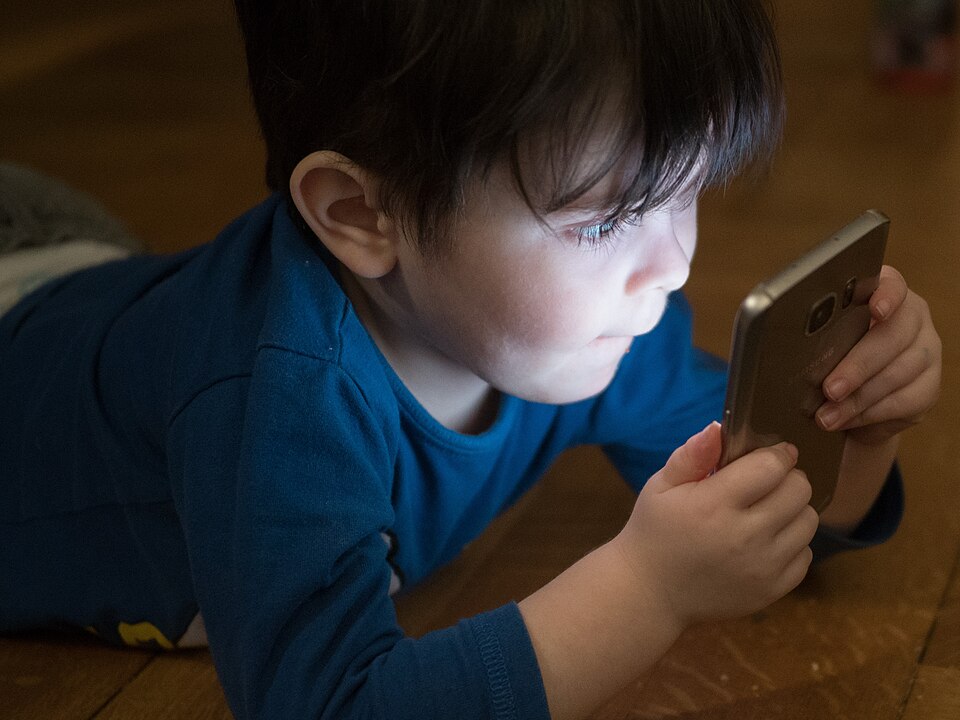 Young child concentrating on a smartphone screen
