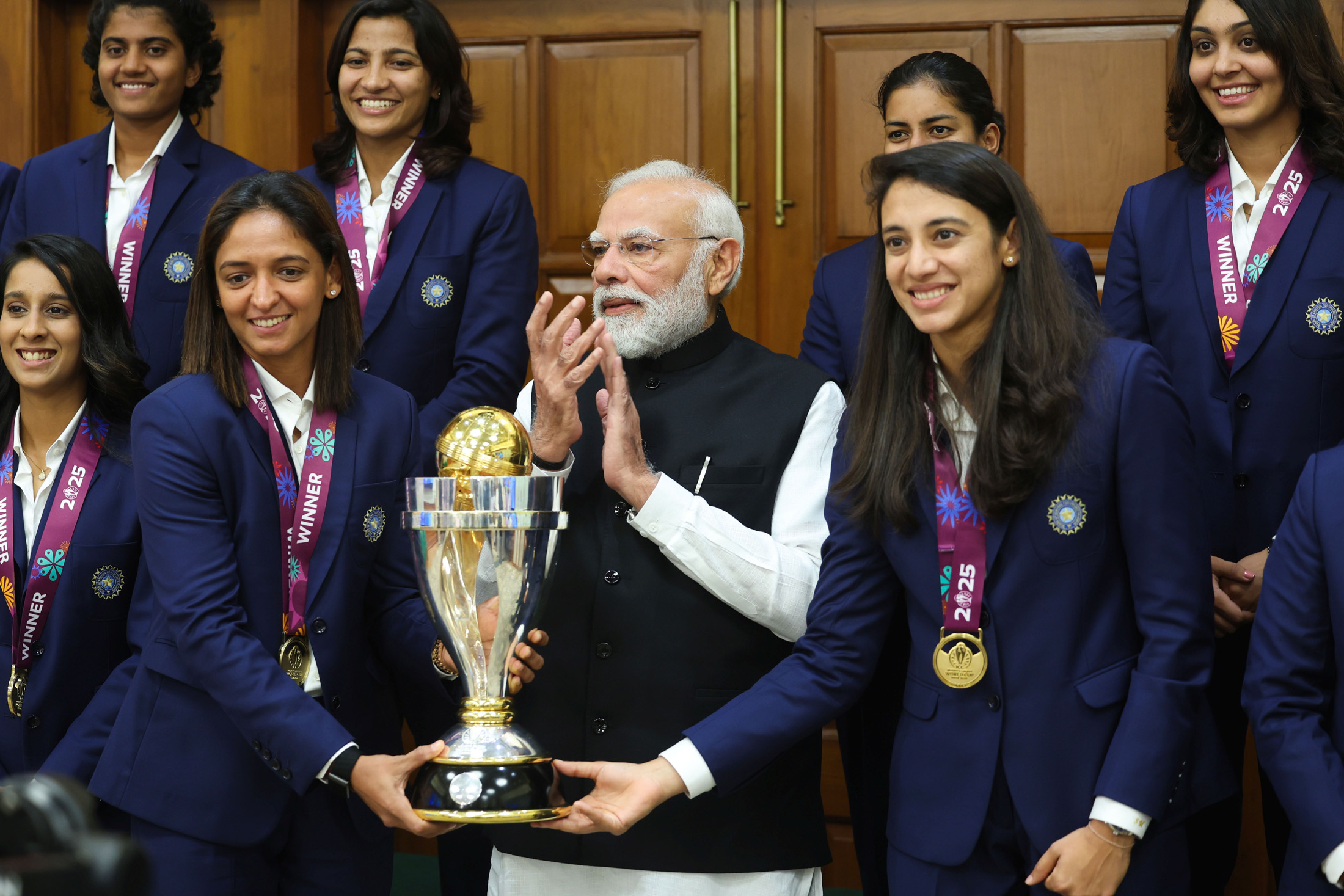 India's women's cricket team poses with the 2025 World Cup trophy at the Prime Minister's residence in New Delhi