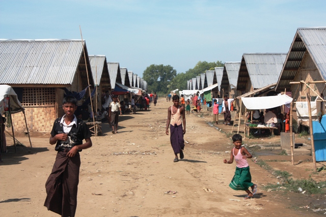 File photo of children standing beside temporary shelters in a displacement camp near Sittwe, Rakhine State