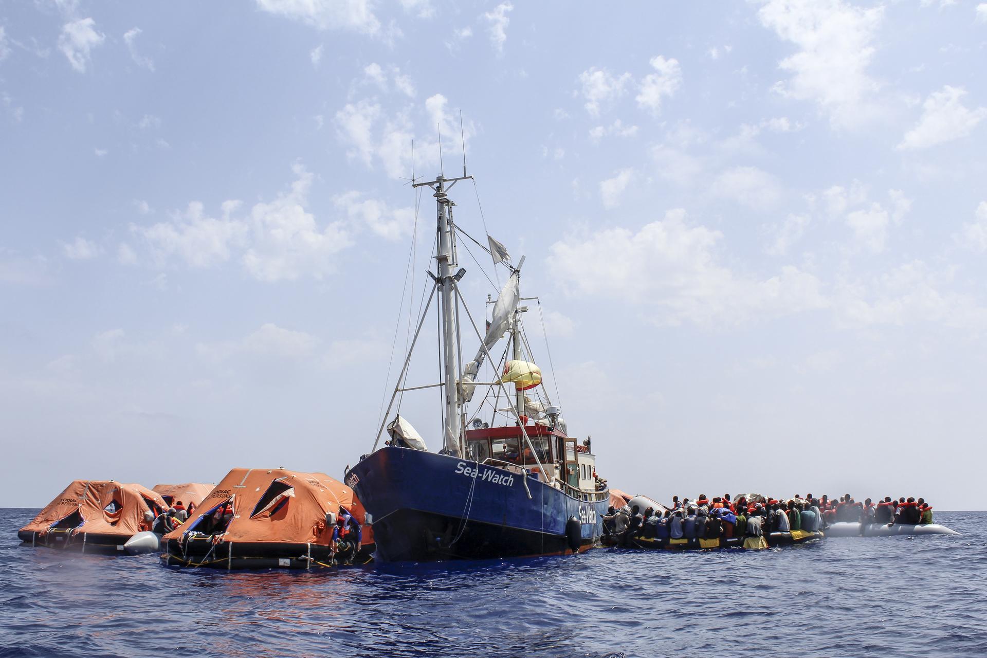 Mediterranean migrant rescue — the Sea-Watch 1 rescue ship beside life rafts carrying migrants in the Mediterranean Sea