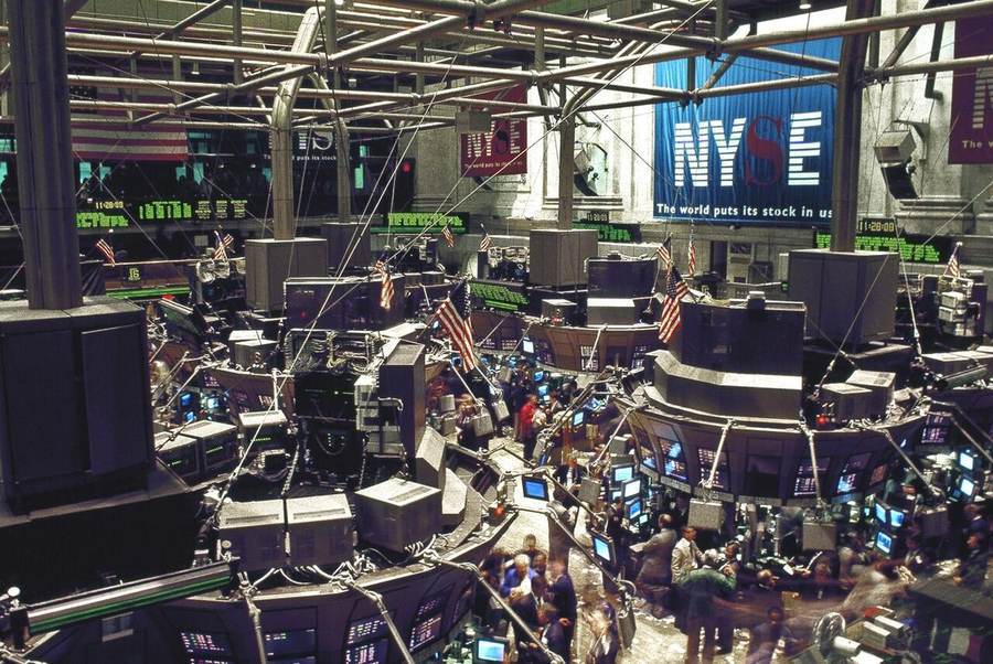 Busy New York Stock Exchange trading floor with electronic screens and trading posts