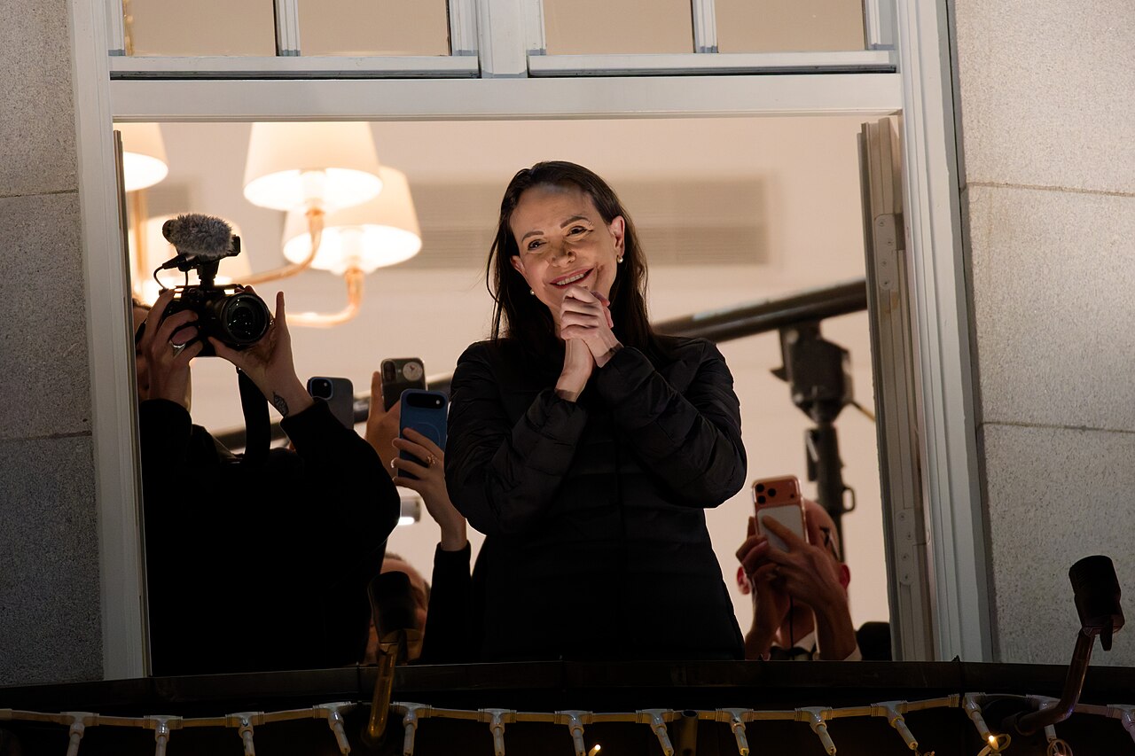 Maria Corina Machado greeting supporters from a balcony during Nobel Week in Oslo in December 2025, at the start of her exile