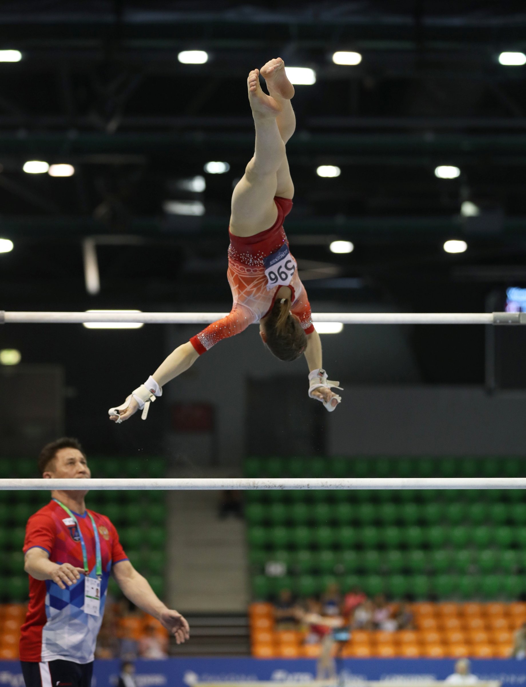 A gymnast on the uneven bars at a FIG event