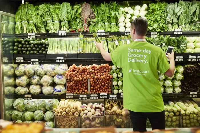 Instacart shopper selecting fresh vegetables in a grocery store — DoorDash buys Instacart 17 billion coverage
