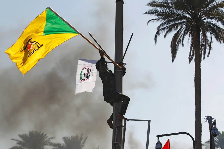 Kata'ib Hezbollah flags — the Iran-aligned Iraqi militia whose leader suspended attacks after U.S. troops left Iraq