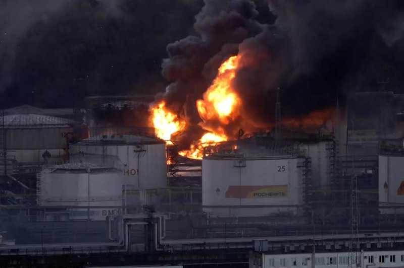 Flames and black smoke rise from storage tanks at a Russian oil refinery in a June 2026 file photograph