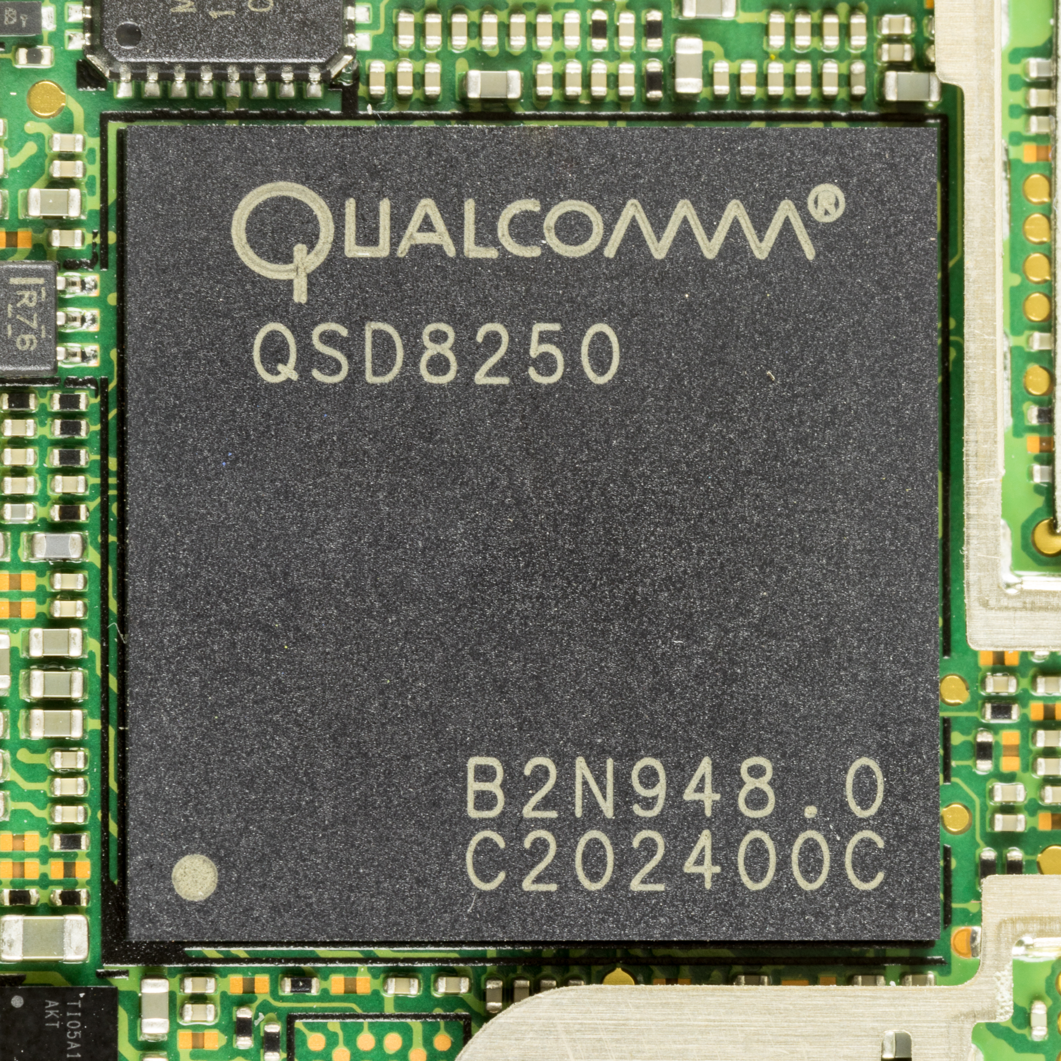 A Qualcomm QSD8250 Snapdragon chip on a phone main board — Qualcomm layoffs follow a slump in smartphone chip demand