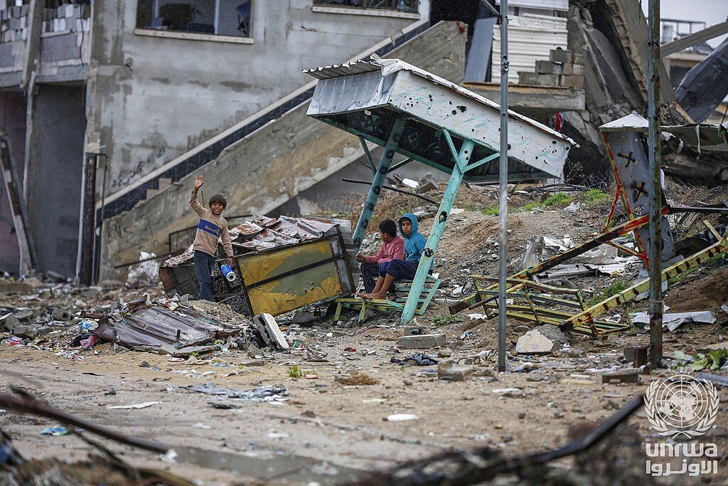 Children sit and stand among the rubble of destroyed buildings in Nuseirat camp in the Gaza Strip — Gaza displaced children file photograph
