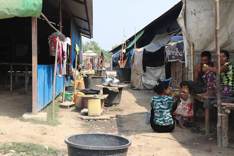 File photo of adults and children beside improvised homes at a displacement camp in Ponnagyun Township