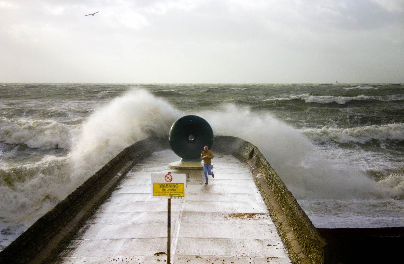 Large storm-driven waves striking a coastal breakwater, illustrating the dangerous surf behind East Coast festival cancellations
