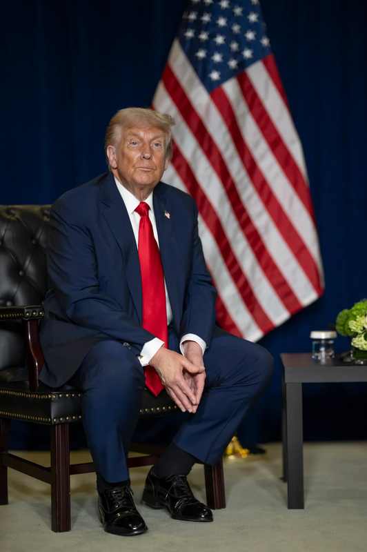 President Donald Trump seated beside an American flag before announcing the Trump Putin diesel deal