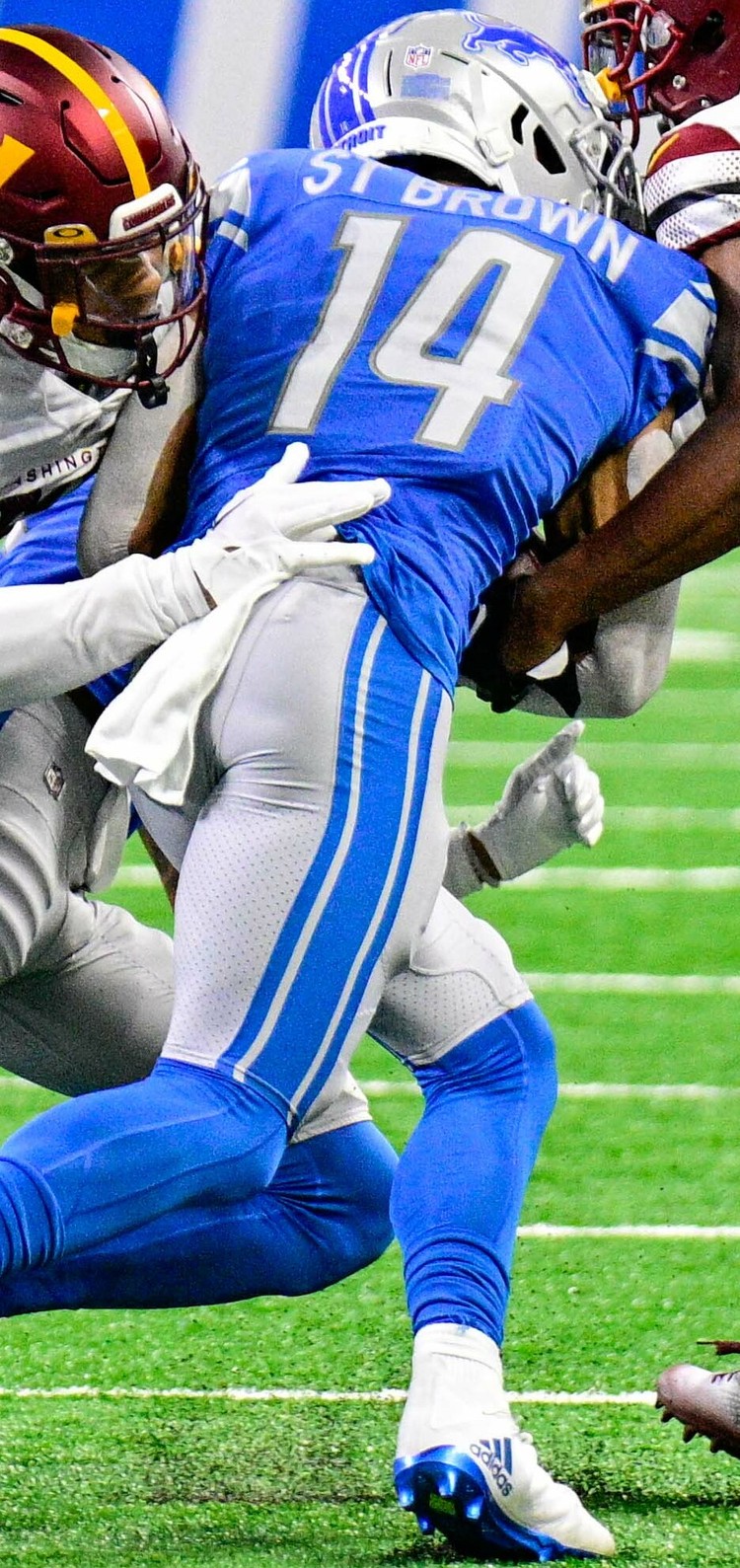 Amon-Ra St. Brown being tackled after a catch at Ford Field — Amon-Ra St Brown stats: nine catches for 153 yards against the Packers