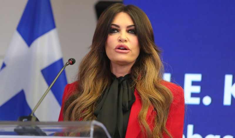 US Ambassador to Greece Kimberly Guilfoyle speaking at a podium in Greece, the ambassador Trump says he is considering firing
