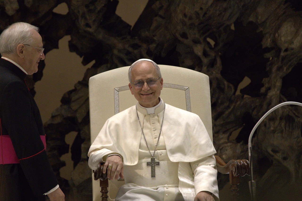 Pope Leo XIV seated and smiling during an audience with journalists at the Vatican
