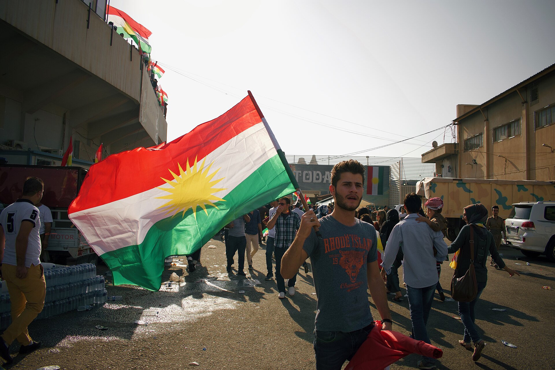 A man carries the Kurdistan flag at a rally in Erbil — Iran strikes Kurdistan Freedom Party base near Erbil