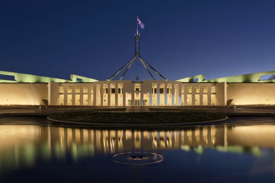 Parliament House in Canberra at dusk — the flydubai co-pilot Australia probe has pulled student-visa vetting into Australia's security debate