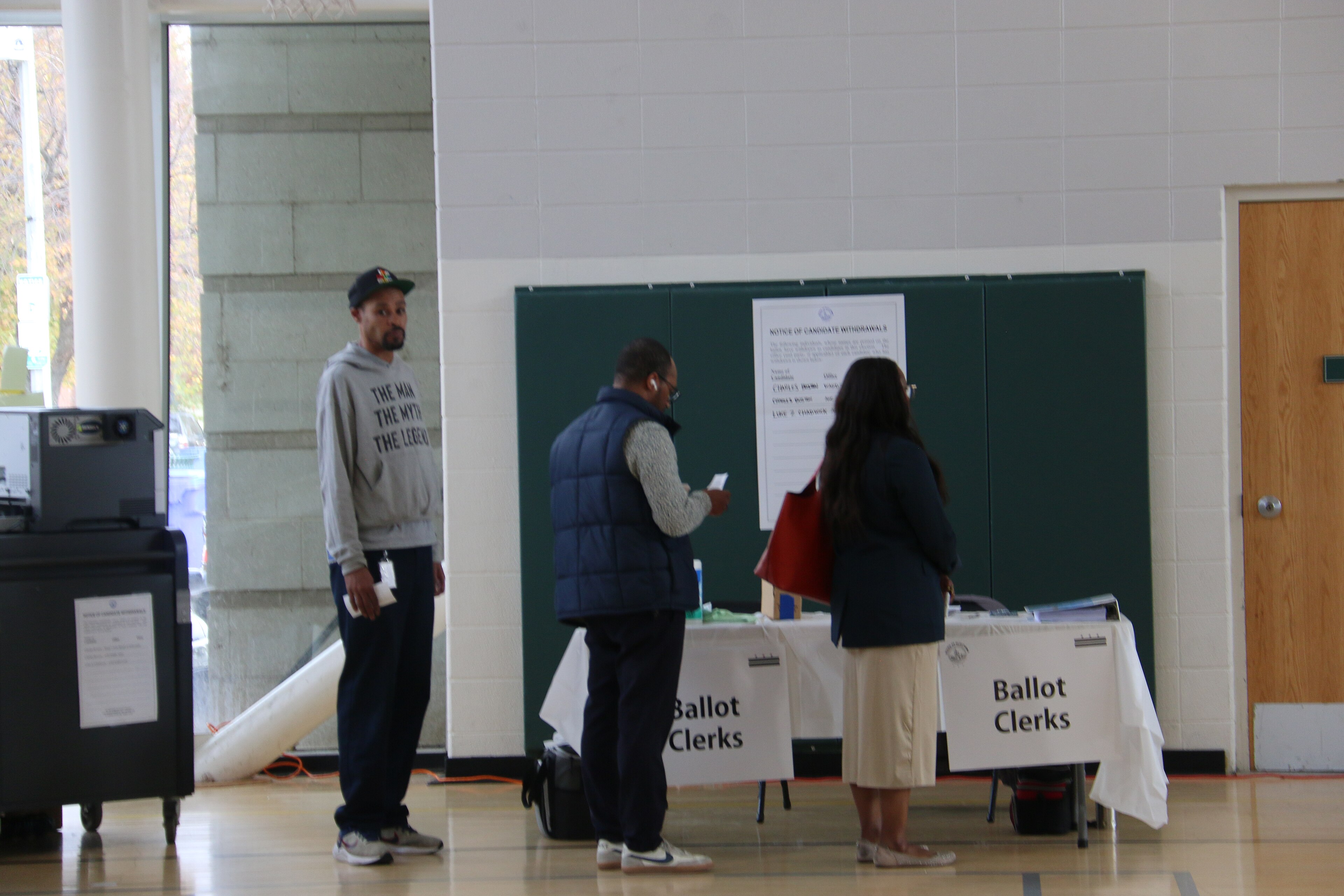 Voters receiving ballots from ballot clerks at a polling station in Washington DC