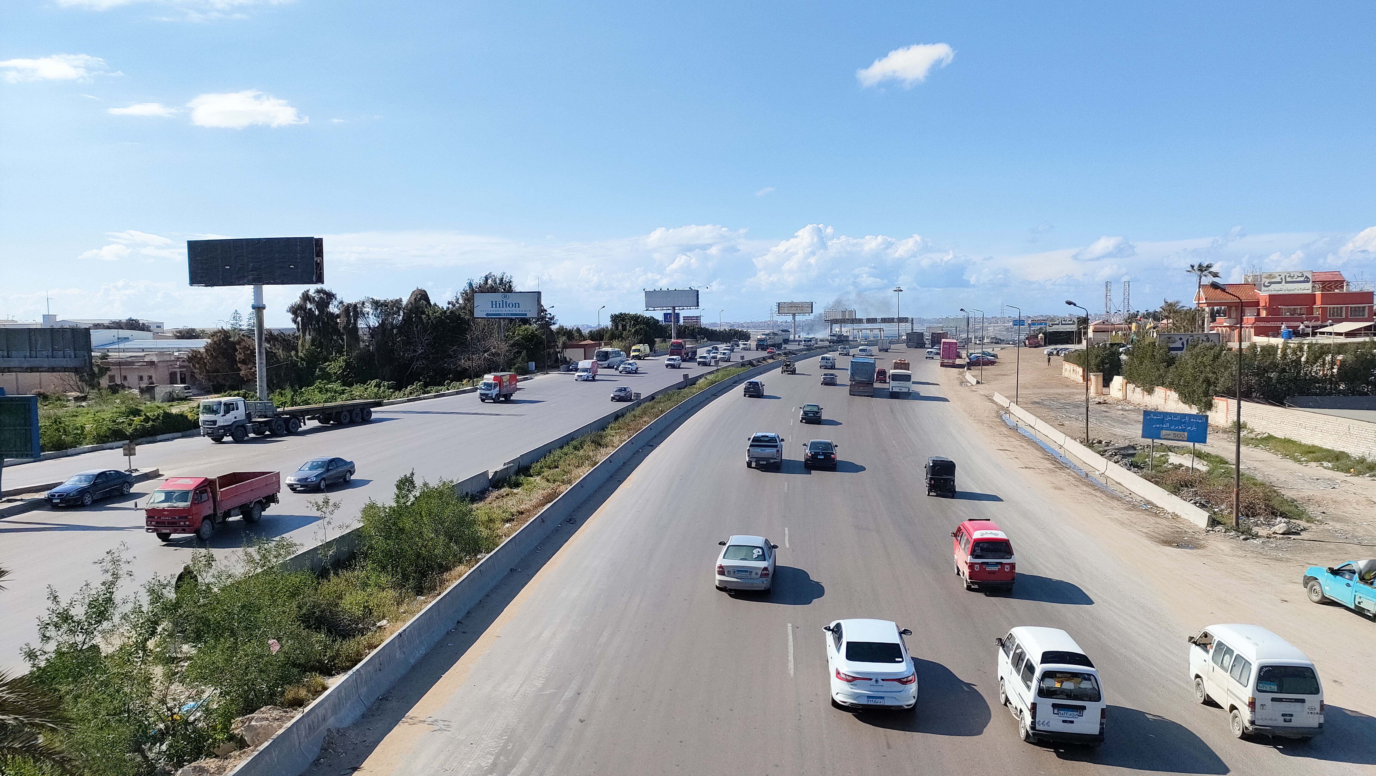 Buses, trucks and vans sharing a divided Egyptian highway — the traffic mix on Egypt's desert roads