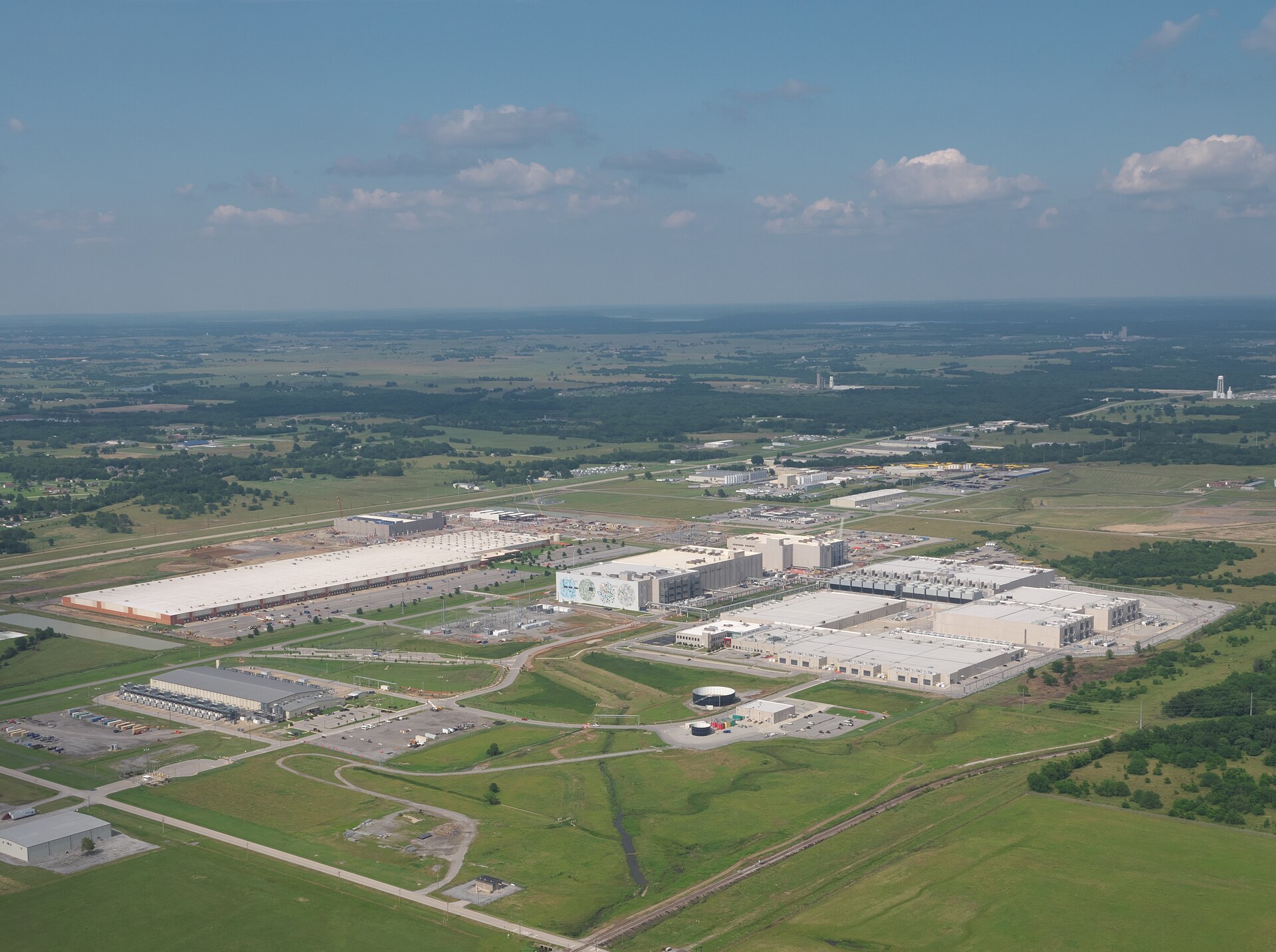 Aerial view of Google's data centre campus in Mayes County, Oklahoma, a sprawling complex of white-roofed halls on green land