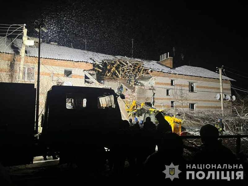 Rescue crews working at night outside a damaged residential building in Sumy Oblast