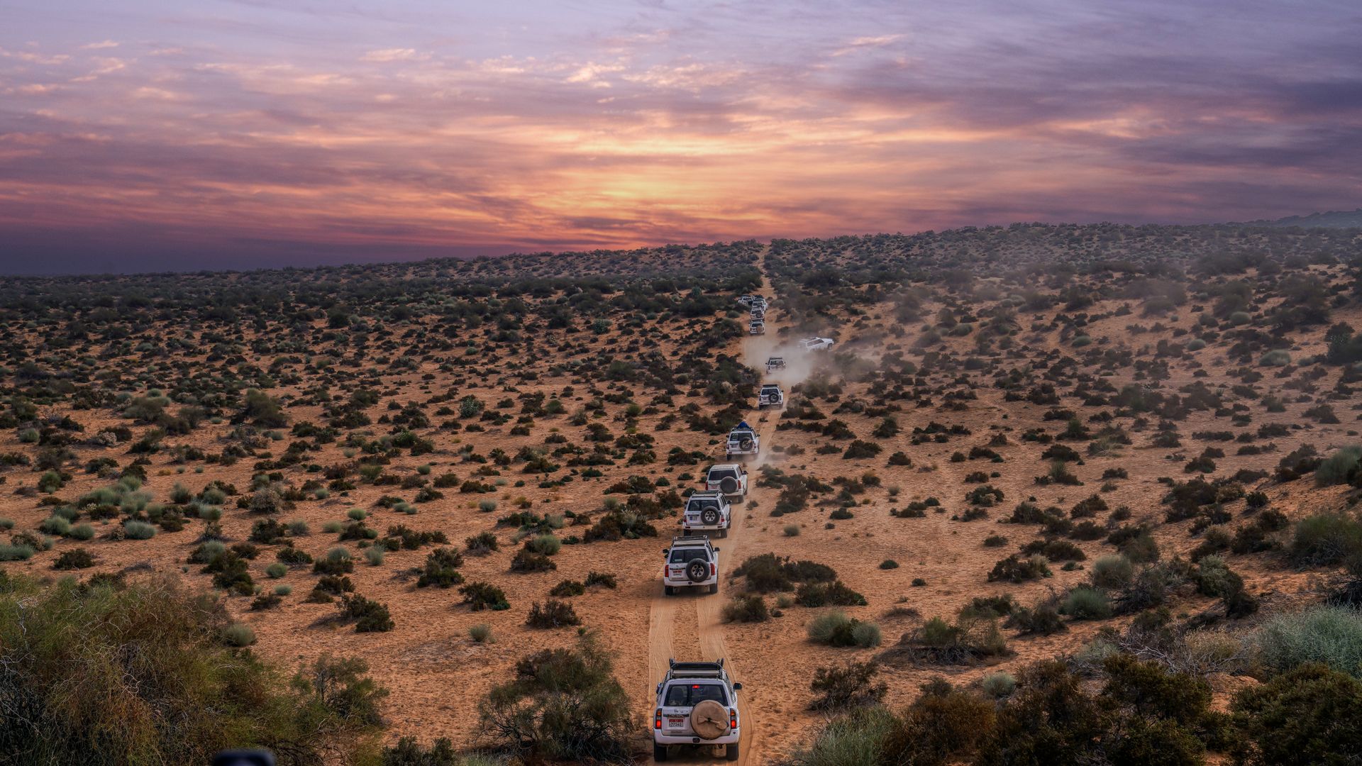 Aid-vehicle convoy crossing a dusty road, illustrating the Sudan aid convoy airstrike
