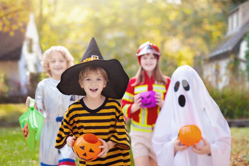 Children in Halloween costumes trick or treating at a decorated house — Halloween costumes 2026 trending coverage