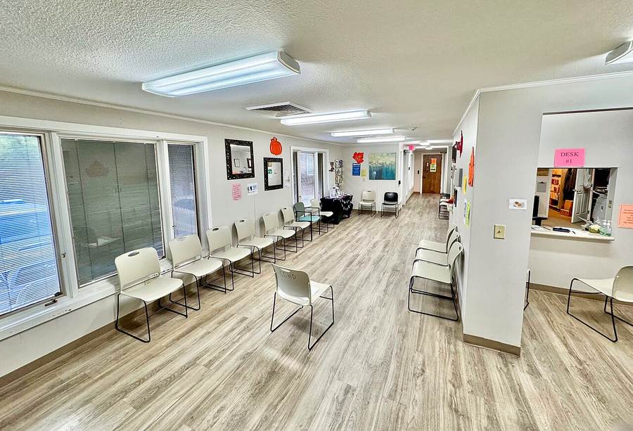 Patients wait inside a community public health department as legal immigrants lose Medicaid coverage under new federal rules