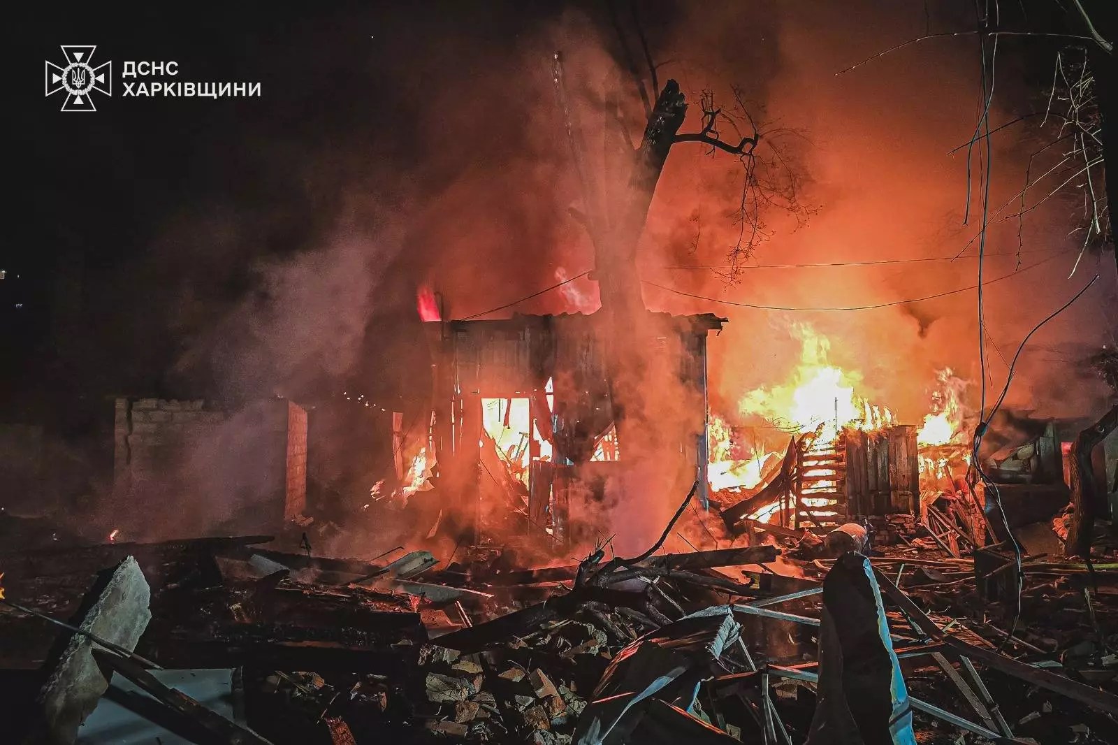 A destroyed Kharkiv house burns at night after a Russian Geran-2 drone strike, rubble strewn across the street — State Emergency Service file photo from the April 3, 2025 attack on the city
