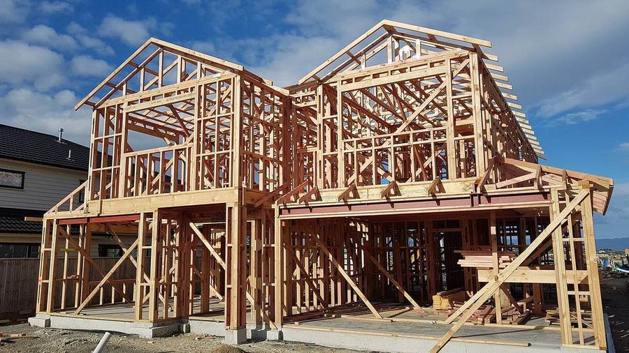 A timber-frame house under construction, representing the timeline from search to closing