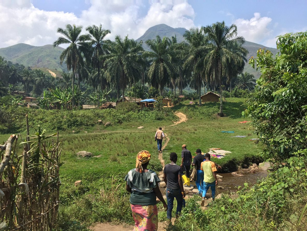 Ebola surveillance and contact tracing team walks a village path in Congo to visit the homes of case contacts